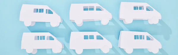 Панорамний знімок білих моделей міні-фургонів на синьому фоні — Stock Photo