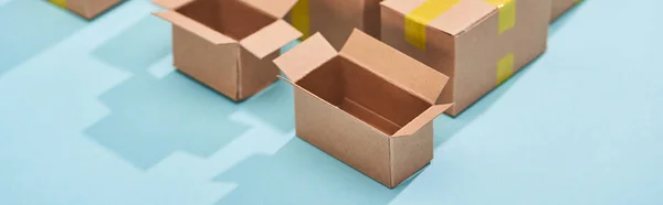 Panoramic shot of open empty postal boxes on blue background — Stock Photo