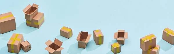 Vista panoramica di scatole postali in miniatura con nastro adesivo giallo su sfondo blu — Foto stock