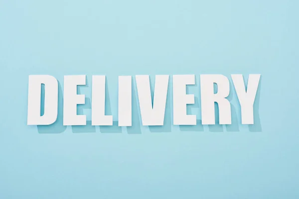 White delivery text with shadow on blue background with copy space — Stock Photo