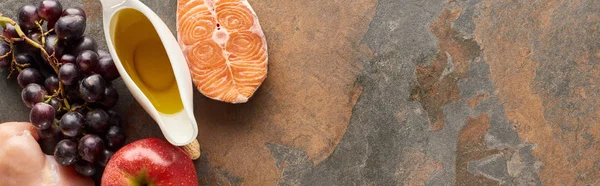 Panorâmica tiro de bife de salmão cru, filé de frango, uva, maçã, azeite na superfície de mármore com espaço de cópia — Fotografia de Stock