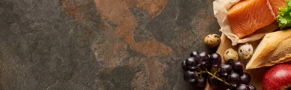 Plan panoramique de saumon cru avec œufs de caille, raisin, pomme, baguette sur la surface du marbre — Photo de stock