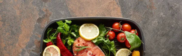 Plano panorámico de salmón crudo con verduras, limón y hierbas en la sartén - foto de stock