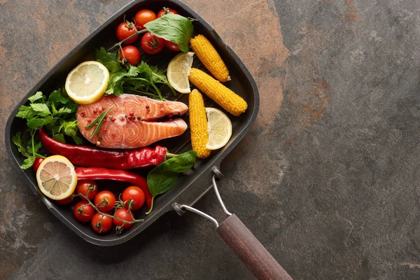 Top view of raw salmon with vegetables, lemon and herbs in grill pan — Stock Photo