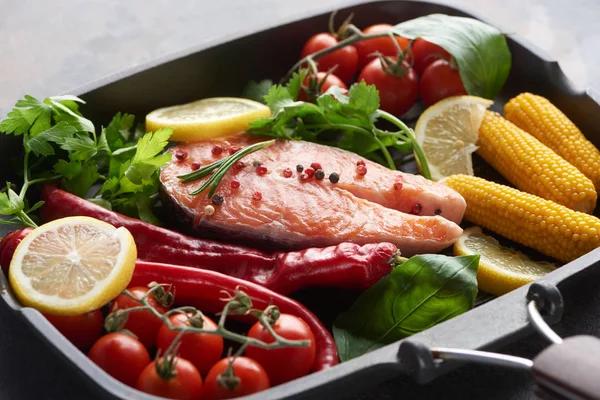 Filete de salmón crudo con especias, verduras y verdura en la sartén - foto de stock