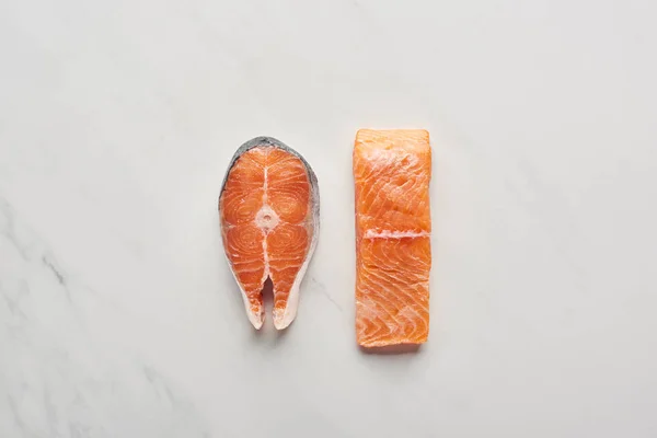 Top view of raw fresh salmon steaks on white marble surface — Stock Photo