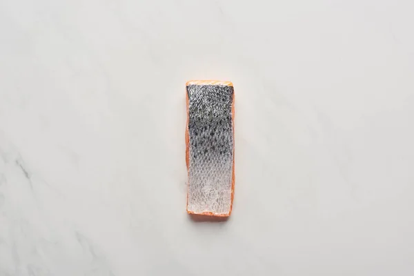Vista superior del filete de salmón fresco crudo con escamas de pescado en la superficie de mármol blanco — Stock Photo