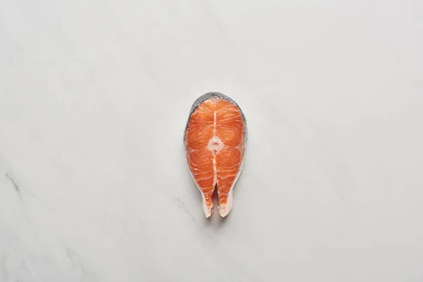 Top view of raw fresh salmon steak on white marble surface — Stock Photo