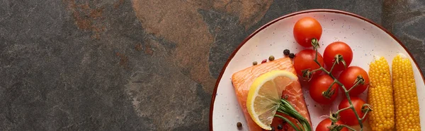 Panoramic shot of raw salmon steak with tomatoes, corn, lemon, rosemary and pepper on plate — Stock Photo