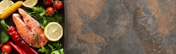 Vue du dessus du saumon cru avec légumes, citron et herbes dans une poêle à griller, vue panoramique — Photo de stock