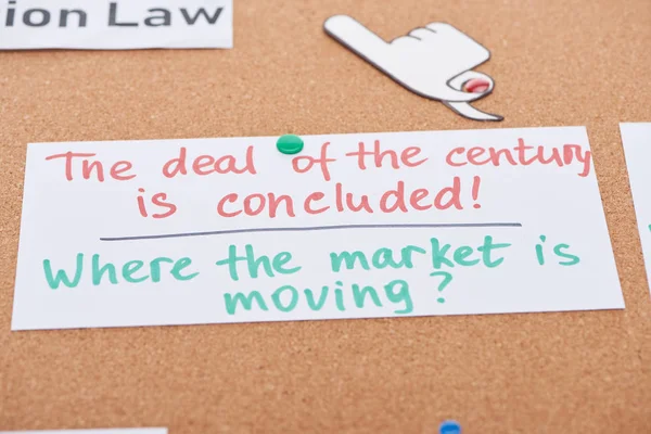 Tarjeta de papel con notas de trabajo y manualidades de papel apuntando con el dedo fijado en el tablero de oficina de corcho — Stock Photo