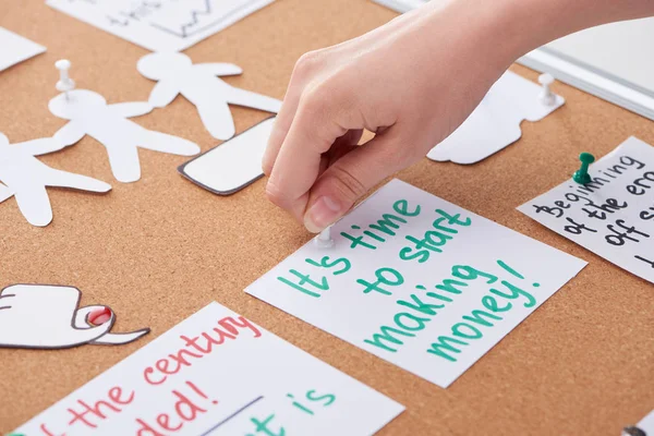 Vista ritagliata della donna appuntare carta con note di lavoro su tavola di sughero — Foto stock