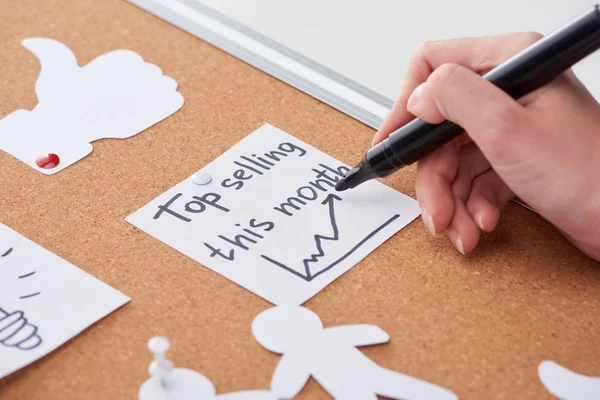 Cropped view of woman holding black highlighter top selling this month — Stock Photo