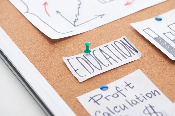 Tarjeta de papel con texto educativo fijado en el tablero de oficina de corcho - foto de stock