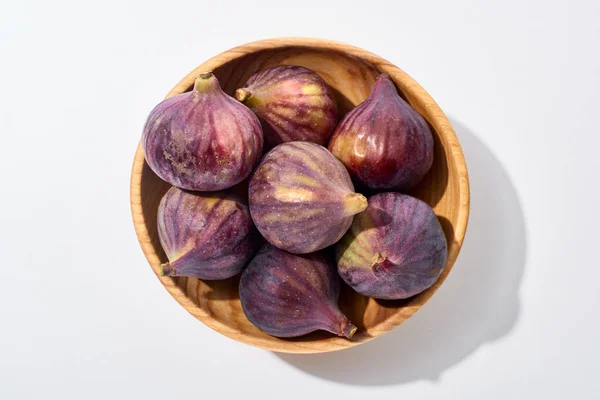 Top view of ripe whole delicious figs in wooden bowl on white background — Stock Photo