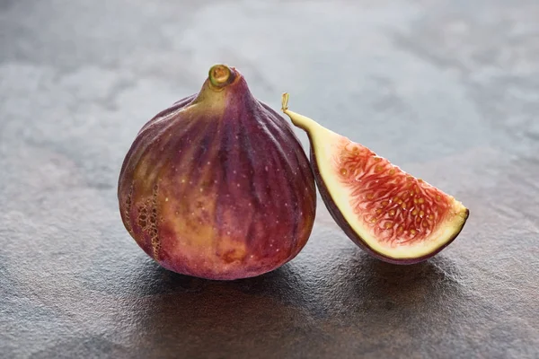 Ripe whole and cut delicious figs on stone background — Stock Photo