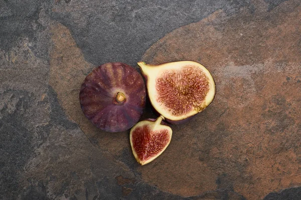 Vue de dessus de figues entières mûres et coupées sur fond de pierre — Photo de stock