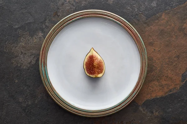 Vista superior de corte maduro delicioso figo na placa branca redonda no fundo de pedra — Fotografia de Stock