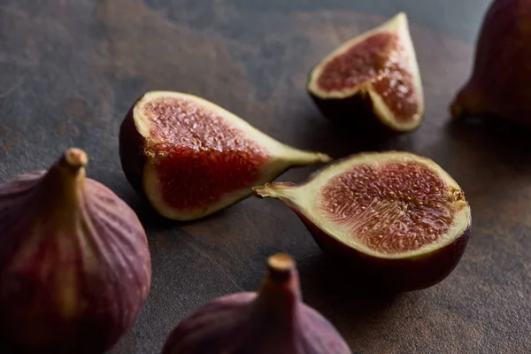 Ripe whole and cut delicious figs on stone background — Stock Photo