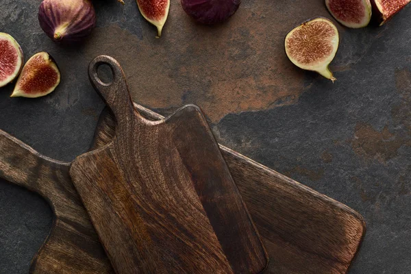 Vue de dessus des figues savoureuses et des planches à découper en bois sur fond de pierre — Photo de stock