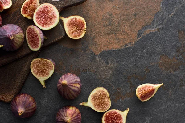 Top view of ripe figs and wooden brown cutting boards on stone background — Stock Photo