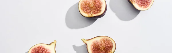 Plan panoramique de figues délicieuses coupées mûres sur fond blanc — Photo de stock