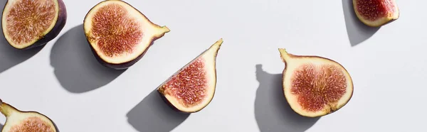 Plan panoramique de figues savoureuses coupées mûres sur fond blanc — Photo de stock