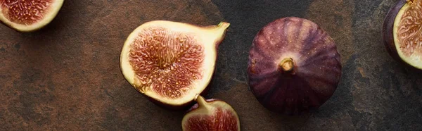 Panoramic shot of ripe whole and cut tasty figs on stone background — Stock Photo