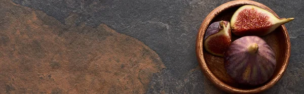 Panoramic shot of ripe delicious figs in wooden bowl on stone background — Stock Photo