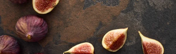 Panoramic shot of ripe whole and cut fresh figs on stone background — Stock Photo