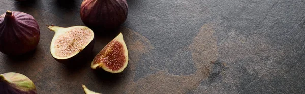 Panoramic shot of ripe whole and cut figs on stone textured background — Stock Photo