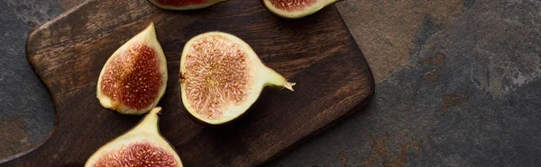 Top view of cut fresh delicious figs on cutting board on stone background, panoramic shot — Stock Photo