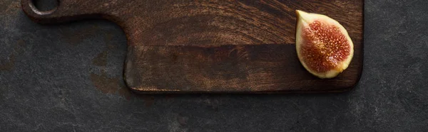 Панорамный снимок спелого инжира на деревянной доске на каменном фоне — стоковое фото