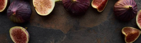 Panoramic shot of ripe fresh whole and cut figs on stone textured background — Stock Photo