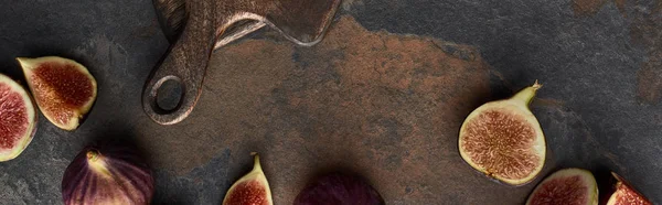 Panoramic shot of ripe figs near wooden cutting board on stone background — Stock Photo