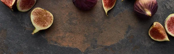 Panoramic shot of ripe fresh whole and cut figs on stone textured background — Stock Photo