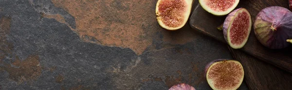Top view of fresh figs and wooden cutting boards on stone background, panoramic shot — Stock Photo
