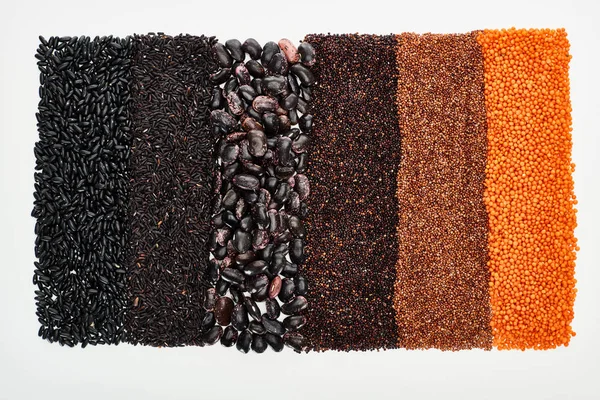 Vista superior de feijão preto sortido, arroz, quinoa, trigo sarraceno e lentilha isolada em branco — Stock Photo