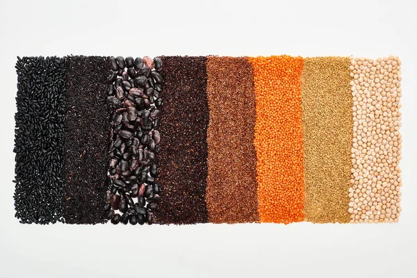 Vista dall'alto di fagioli neri assortiti, riso, quinoa, grano saraceno, ceci e lenticchie isolate su bianco — Foto stock