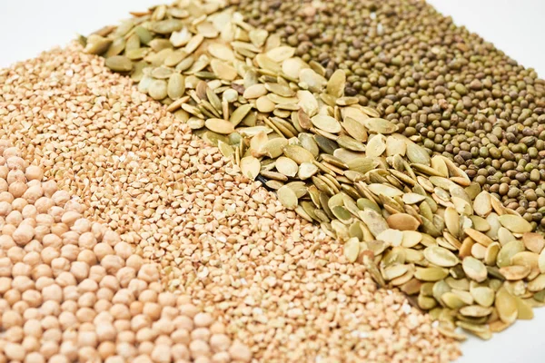 Garbanzos crudos, trigo sarraceno, frijoles mungo y semillas de calabaza aislados en blanco — Stock Photo