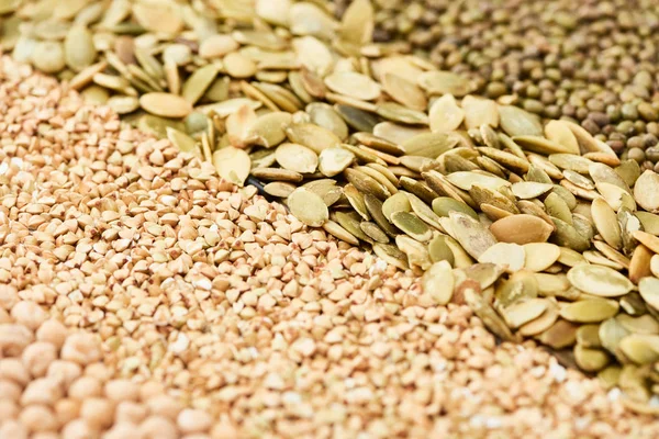 Primer plano vista de trigo sarraceno sin procesar cerca de semillas de calabaza y frijoles mungo - foto de stock