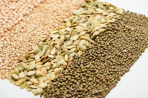 Feijão-mungo verde, sementes de abóbora, grão-de-bico e trigo sarraceno cru isolado em branco — Fotografia de Stock