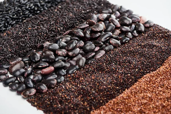 Raw black beans, wild rice, quinoa and roasted buckwheat isolated on white — Stock Photo