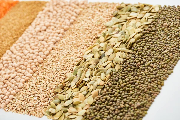Semi di zucca grezzi vicino a maash, ceci e grano saraceno verde isolati su bianco — Foto stock