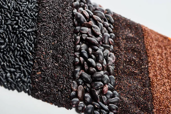 Quinoa nera cruda, fagioli, riso selvatico e grano saraceno isolati su bianco — Foto stock