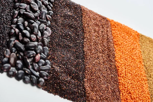 Lentille rouge non cuite, sarrasin, quinoa noir et graines de haricots isolés sur blanc — Photo de stock