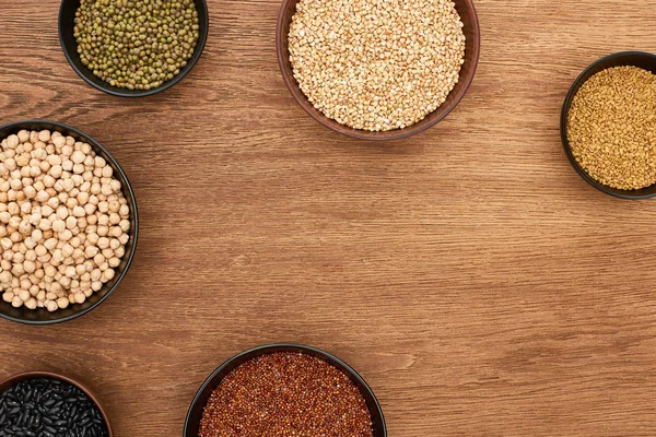 Top view of bowls with beans, buckwheat and chickpea on wooden surface with copy space — Stock Photo