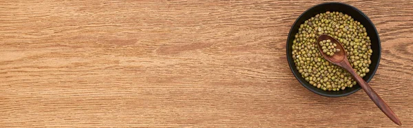 Panoramaaufnahme einer Schüssel mit grünen Bohnen mit Löffel auf Holzoberfläche — Stockfoto