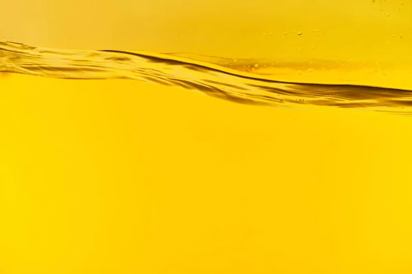 Wavy clear fresh water on yellow background — Stock Photo