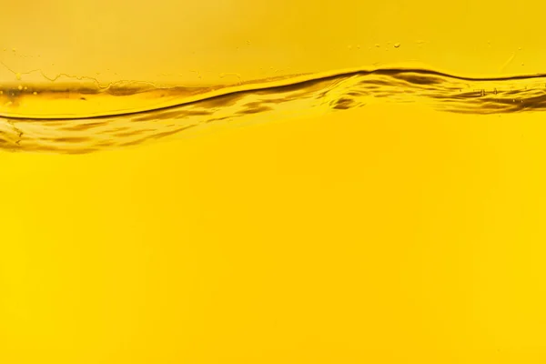 Agua dulce clara ondulada sobre fondo amarillo brillante - foto de stock